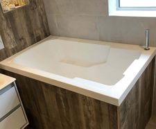 Nirvana deep soaking tub in wood-panelled surround