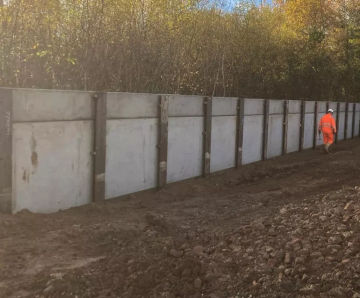 Low vibration rigid inclusions and King Post retaining wall