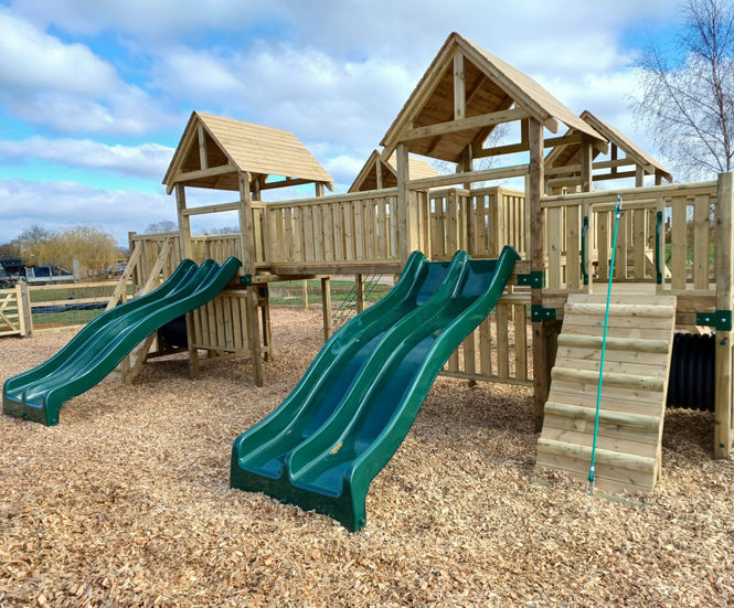 Large wooden climbing frame and swings installed at country park