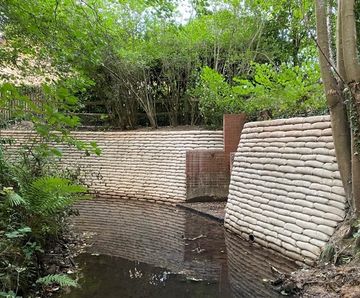 Concrete filled bagwork for retaining walls