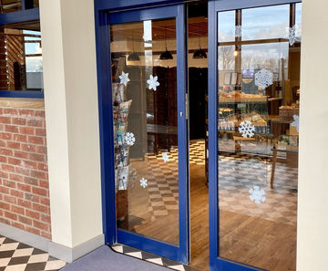 Bi-parting sliding doors provide easy access to new bakery shop