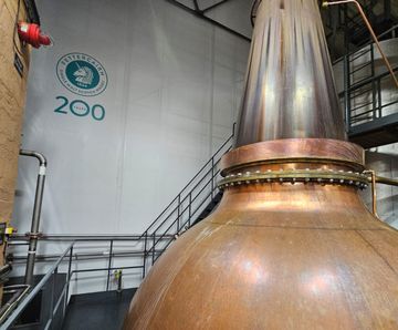 Durable, wind-loaded, custom-branded screen for distillery site separation