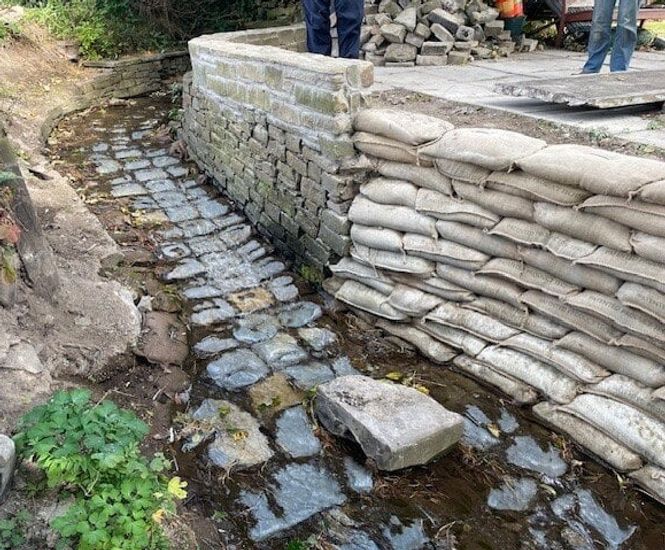 Pre-filled concrete bagwork repairs stream embankment - Dundee
