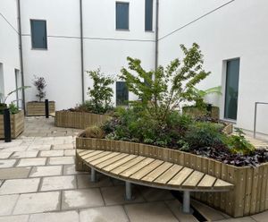Raised timber planters with integrated bench seating for courtyards