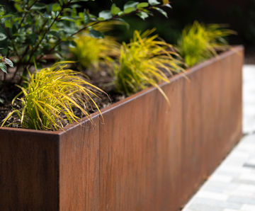 Large wavey corten steel planter beds for public space