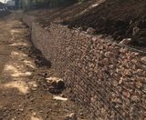 Welded mesh gabion wall retains flood basin and hedge - on this page