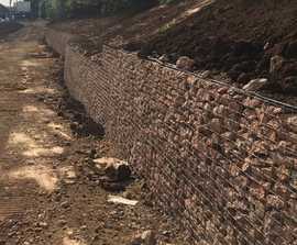 Welded mesh gabion wall retains flood basin and hedge