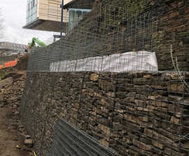 Gabion baskets support existing stone wall at university