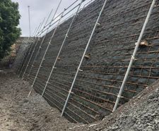 Reinforced soil wall and retaining wall for development