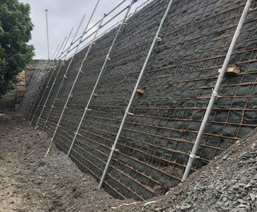 Reinforced soil wall and retaining wall for development