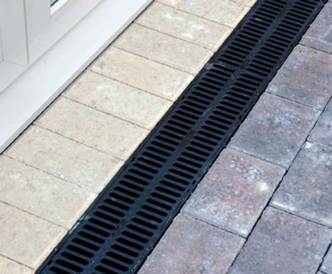 An illustration showing a well-maintained drainage system with clean gutters, French drains, and a slope directing water away from a house.