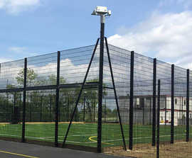 Integrated floodlight posts for sports fencing